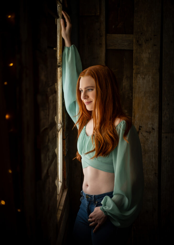 Woman staring intently out the window with bright red hair