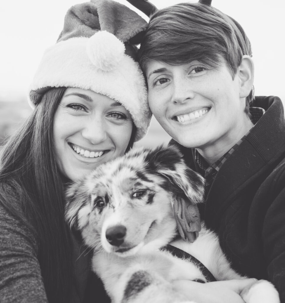 Beautiful female couple with their smiling Australian Sheppard