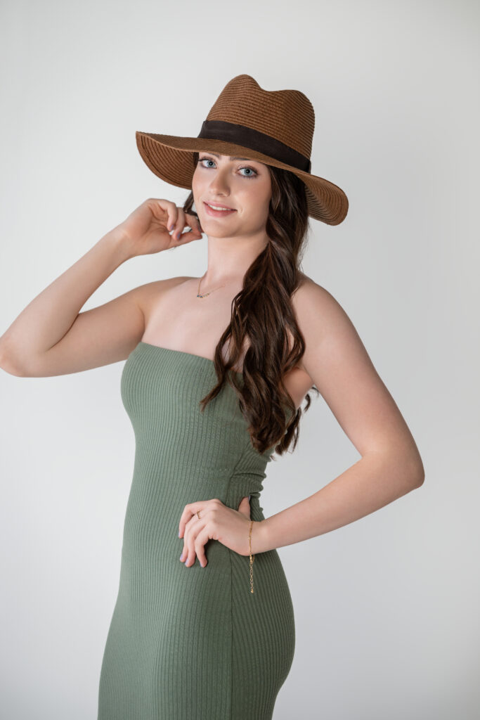 High school senior is a green dress and cowboy hat