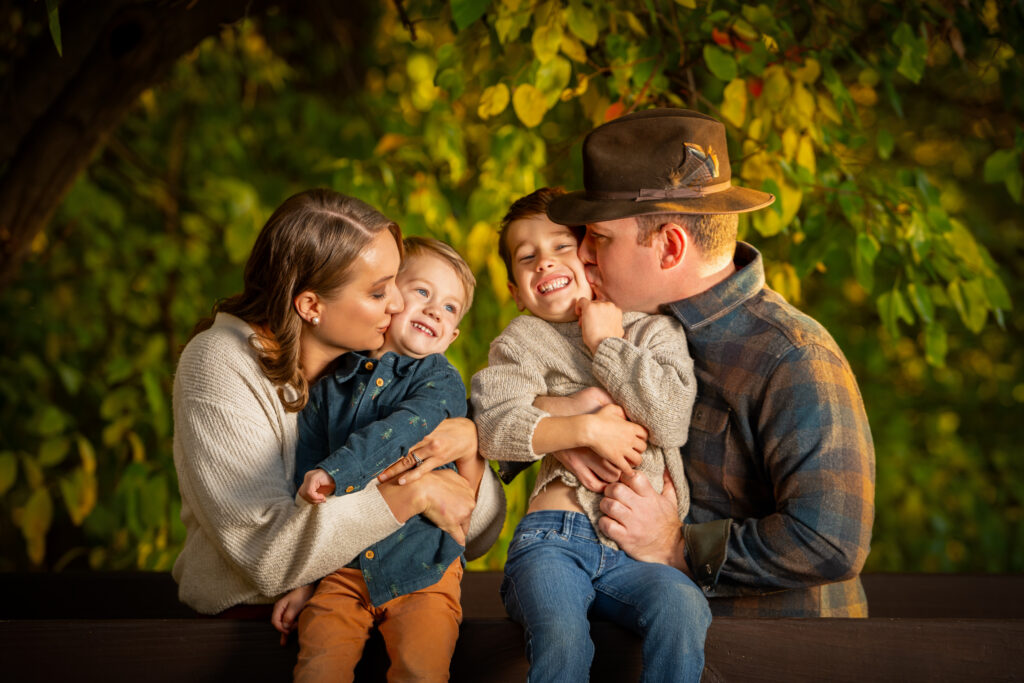 Family of four during the fall having fun in the trees